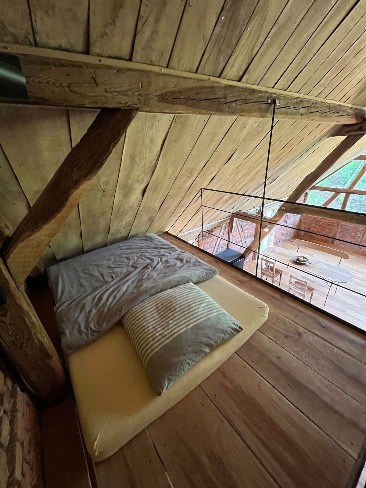 Hochbett unter dem Dach im Loft des Gesäßhofs mit Blick in den Wohnraum
