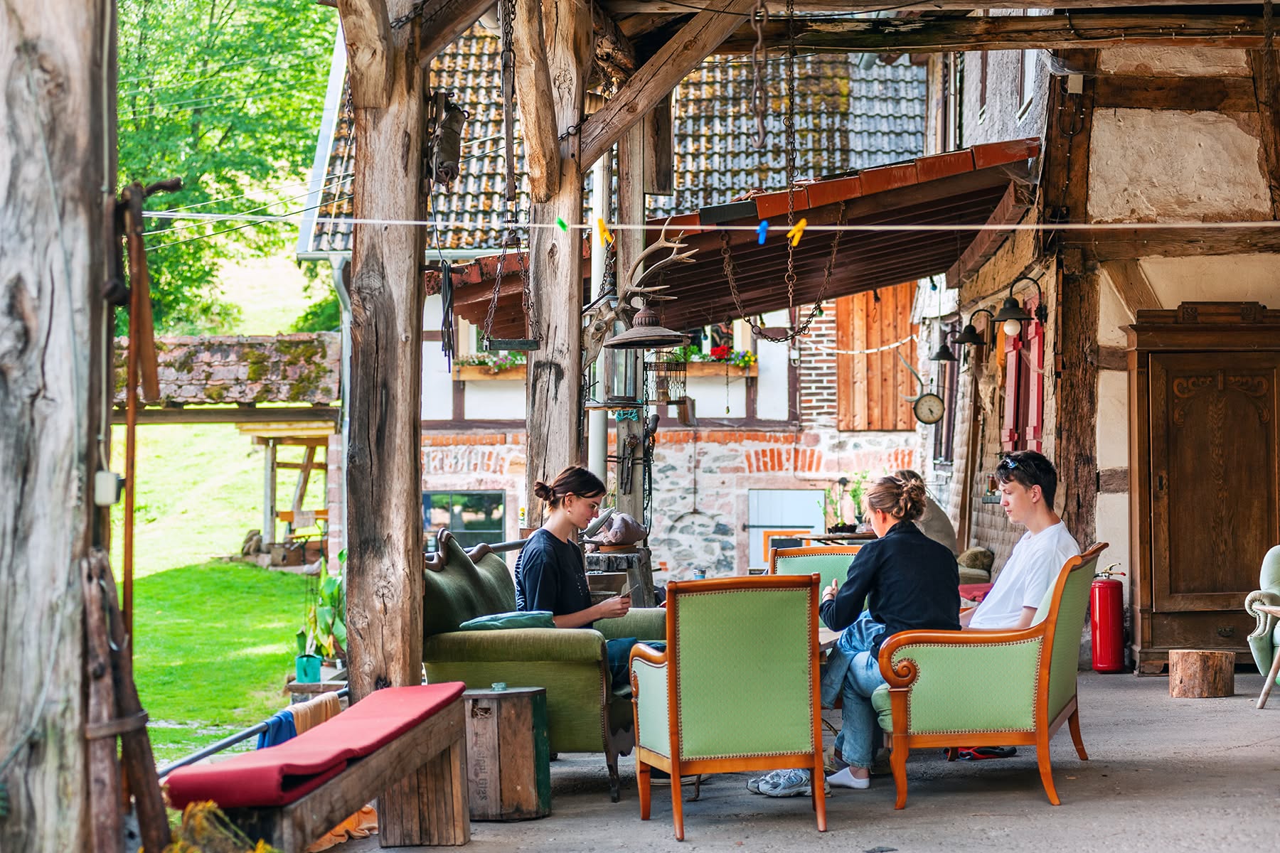 Gäste sitzen in Sesseln im überdachten Loungebereich des Innenhofs am Gesäßhof
