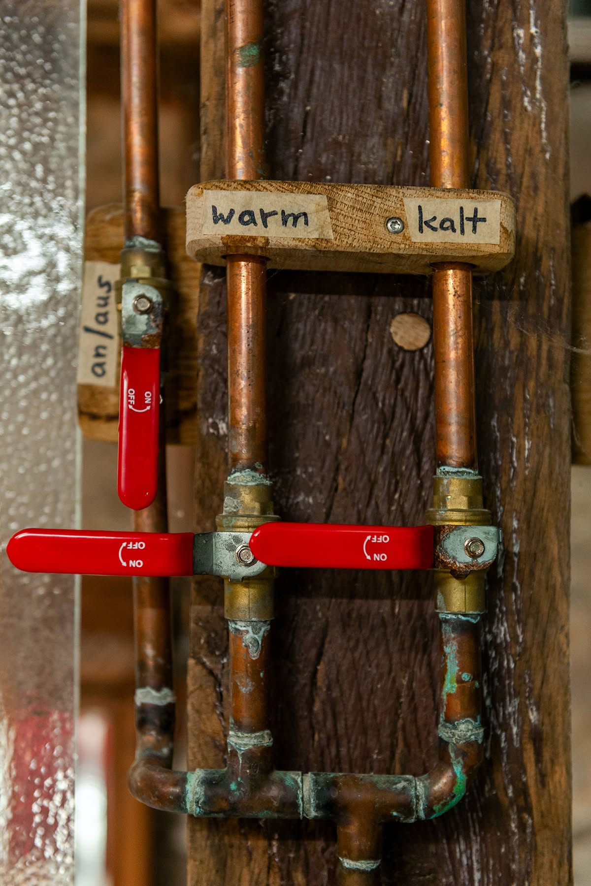 Detail der Kupferarmatur mit handbeschrifteten Schildern warm und kalt am Gesäßhof