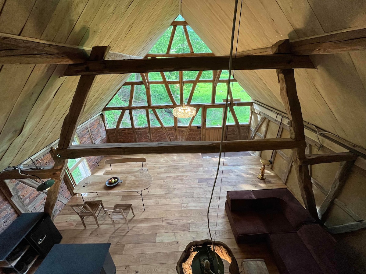 Blick auf Dachstuhl und Fachwerkfenster im Loft des Gesäßhofs