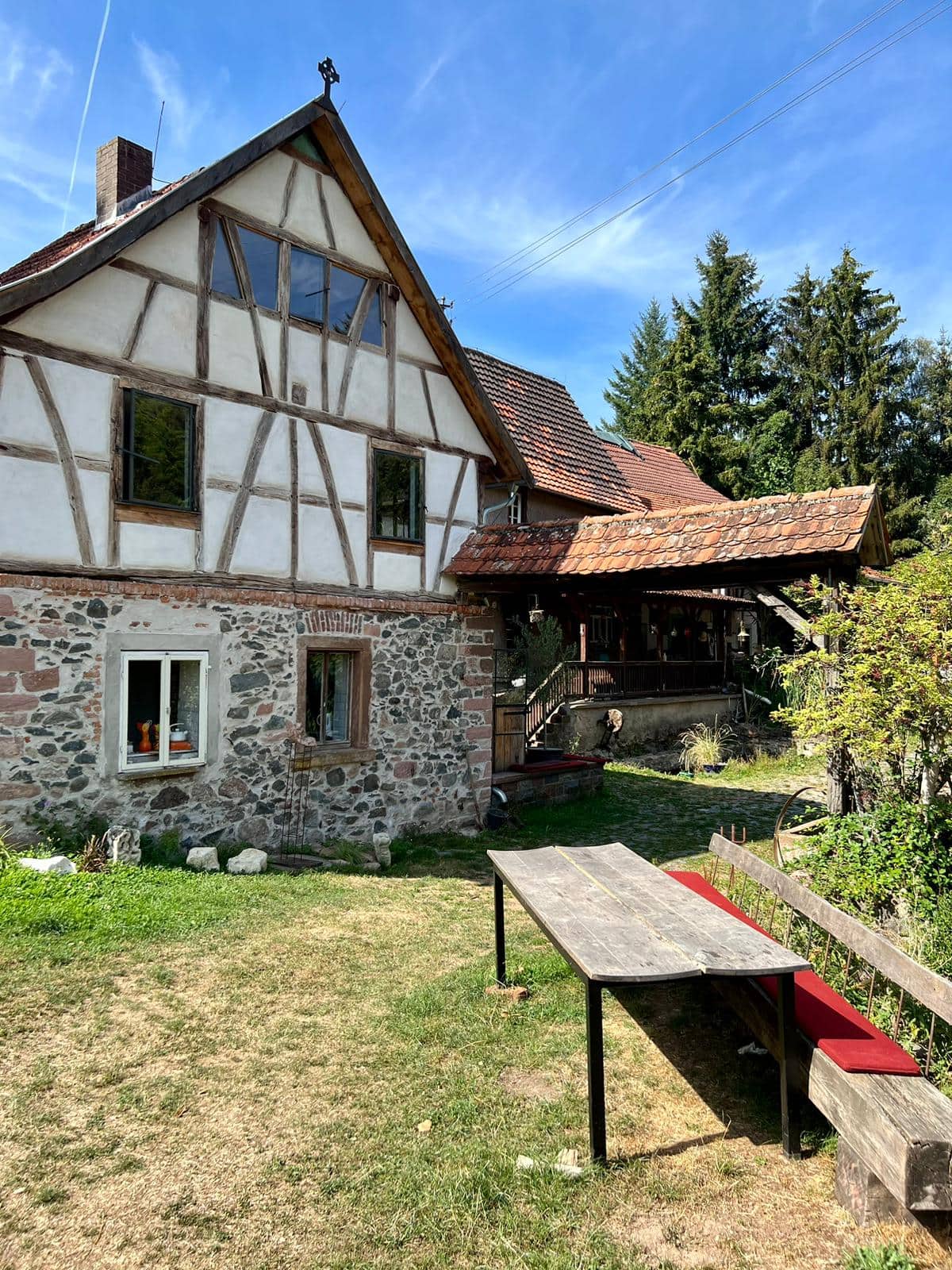 Fachwerkhaus des Gesäßhofs mit großer Wiese und langer Holztafel davor